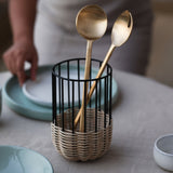 A medium-sized kitchen utensil holder with a minimal design, featuring natural rattan on a powder-coated iron frame.