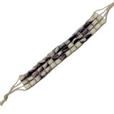 Beaded bracelet with white and purple shell beads on a white background
