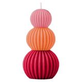 Stack of three colorful ribbed balls candle on a white background