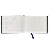 An open hardcover journal or notebook with lined pages for a daily log, featuring a dark navy blue cover and a matching dark ribbon bookmark, shown on a plain white background.