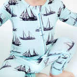 Baby outfit with sailboat pattern on a light blue background