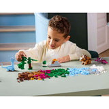 Child playing with LEGO figurines and sets on a table