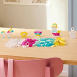 Children's craft materials on a table with a pink chair in the foreground