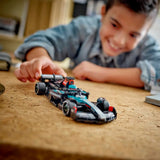 Child playing with a toy Formula 1 car on a wooden table