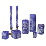 Set of blue candles with white patterns on a white background