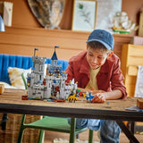 Child playing with a toy castle set on a wooden table
