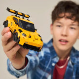 Child holding a yellow toy car with a blurred background