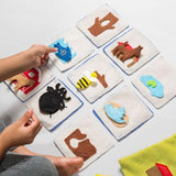 Children's educational mat with animal shapes and a hand pointing to one of them.