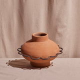 A terracotta vase with scalloped brown metal trim, suitable for decorative use.