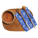 Wooden bowl, fork, and spoon on a blue patterned napkin with a wooden tray.