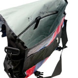 Colorful messenger bag open to show interior on a white background