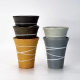 Five ceramic cups stacked in two pairs, shown on a plain light background.