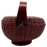 Red wicker basket with a lid on a white background