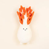 White plush kimchi toy with orange leaves on a beige background