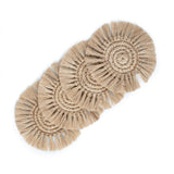 A set of four handwoven, natural fibre coasters in a spiral pattern with fringe edging.