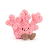 A plush toy resembling a pink coral with a smiling face and brown eyes