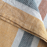 Close-up of woven fabric samples in gold, gray, and white.