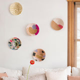 Decorative wall art with colorful circular patterns on a white wall above a beige sofa.