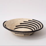 Woven basket with black and beige pattern on a white background