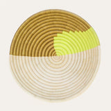 Round woven trivet with brown, yellow, and beige colors on a white background