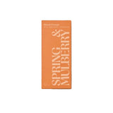 A rectangular orange product box with white text reading 'SPRING & MULBERRY' and smaller text 'Blood Orange' and 'Blossom & Mulberry Confectionery,' centered on a peach-pink textured background.