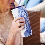 Person holding a blue and white patterned tumbler outdoors