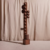 A wood sculpture of geometric shapes with a walnut finish.