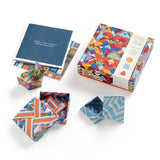 Colorful geometric-patterned origami boxes with a book of instructions on a white background