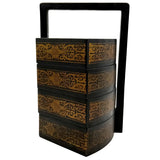 Decorative black and gold tiered box with a handle on a white background