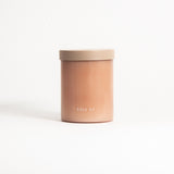 A beige, round soy wax candle with a label that reads 'field kit' placed on a white background.