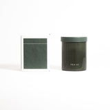 A green glass jar labeled 'FIELD KIT' containing a candle.
