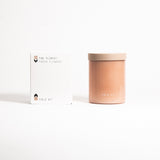 A beige, cylindrical glass jar with a lid labeled 'FIELD KIT' containing a candle.