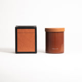 A glass jar with a lid labeled 'FIELD KIT' containing a brown-colored candle.