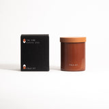 A glass jar with a lid labeled 'FIELD KIT' containing a brown-colored candle.