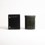 A green glass jar with a green lid labeled 'FIELD KIT' containing a home candle.