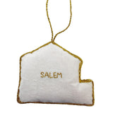 White ornament shaped like the East India Marin Hall with 'SALEM' embroidered on it, hanging from a string.