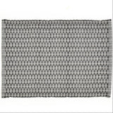 A placemat with a geometric pattern, predominantly in black and white.