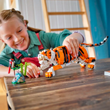 Child playing with a toy tiger on a wooden table