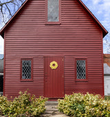 A handcrafted yellow rope sailor's wreath with a traditional Turk’s Head knot, hanging on a red door.