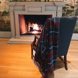 A tartan blanket draped over the back of a chair in front of a fireplace