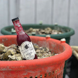 Bottle of red sauce with label the reads ' Lighthouse Keepers Cape Cod Cranberry Lime Hot Sauce'