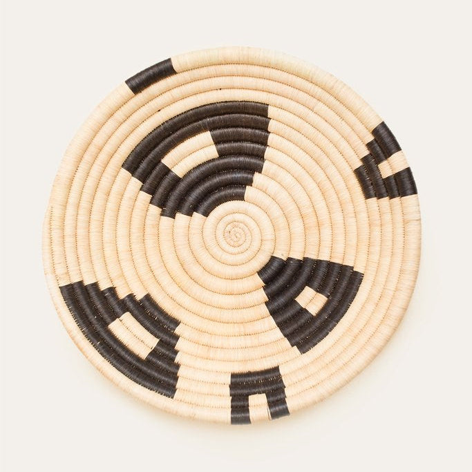 Woven basket with black and beige pattern on a white background
