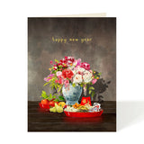 A New Year greeting card featuring a still life illustration of a floral arrangement in a blue patterned vase, with red trays of fruit and sweets, and the text 'happy new year' in gold at the top. 