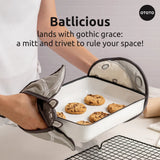 Person holding a baking tray with cookies using an oven mitt, with text about 'Batlicious' and 'OTOTO'.