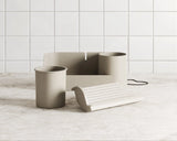 Beige fountain and accessories on a light wooden floor with white tiled wall