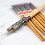 Set of wooden chopsticks with colorful packaging on a white marble surface