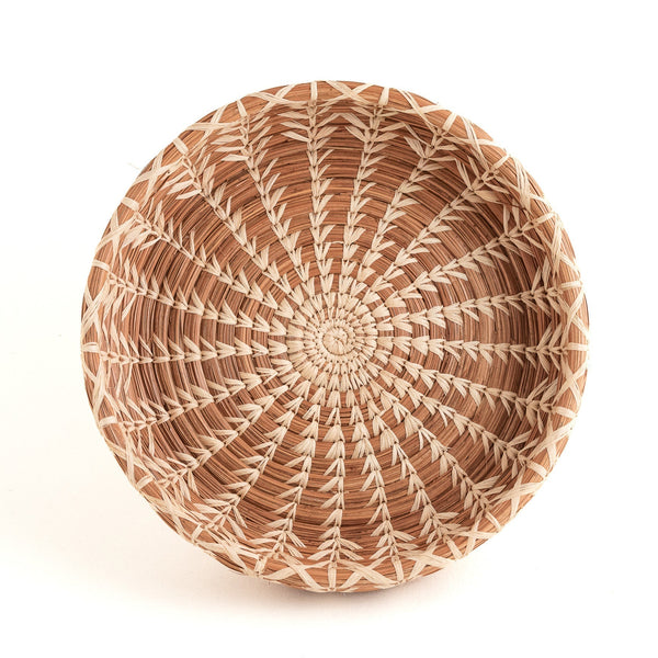 Woven basket with a circular pattern on a white background