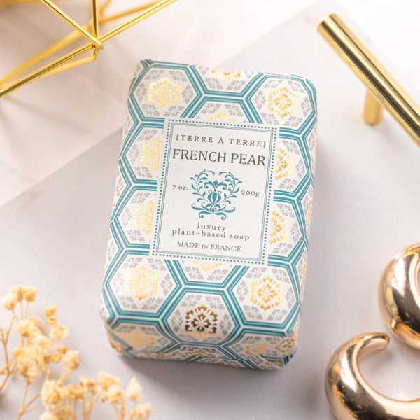 Soap bar with decorative packaging on a light surface with gold accents