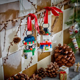 Decorative LEGO Christmas ornaments on a branch with pine cones and a tiled wall background