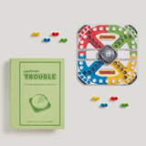 Trouble board game set with green bookshelf edition packaging on a white background